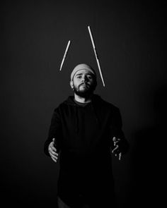 black and white photo of man with two sticks sticking out of his head in front of him