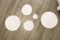 three white circles sitting on top of a wooden floor