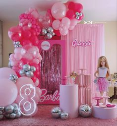 a barbie doll is standing in front of balloons and other decorations on the floor at a barbie birthday party