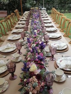 a long table with plates and flowers on it