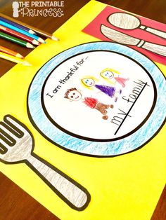 a paper plate with a fork and spoon on it next to colored crayon pencils