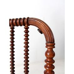 an old fashioned wooden bed frame with wood posts and spindles on the top, against a white background