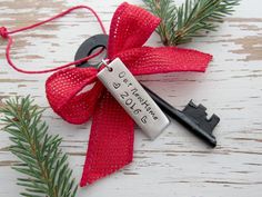 a pair of scissors with a red ribbon tied around it on top of a wooden table