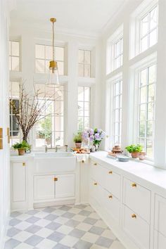 a kitchen filled with lots of windows and white cabinets