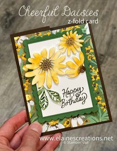 a hand holding up a card with yellow flowers on it and the words happy birthday