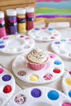 a cupcake on a plate with sprinkles and hearts in the background