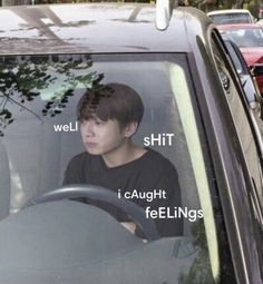 a young man sitting in the passenger seat of a car with words written on it