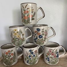 a stack of coffee mugs sitting on top of a wooden table