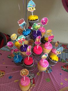 cupcakes are arranged in the shape of a tree on top of a table