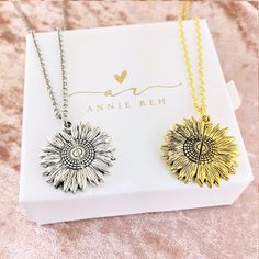 two sunflower necklaces sitting on top of a white box