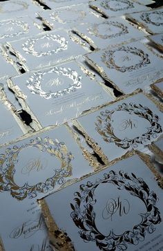 many different types of wedding cards are on the table together with gold and silver foil