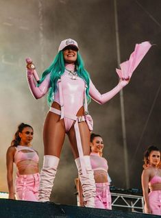 a group of women in pink outfits standing on top of a stage