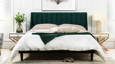 a bed with green velvet headboard and foot board in a white walled bedroom area