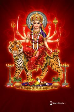 the hindu goddess sitting on top of a tiger and holding a candle in her hand