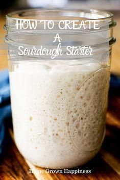 a jar filled with white liquid sitting on top of a wooden table next to a blue towel