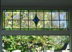 a stained glass window above a sink in a bathroom with green leaves on the windowsill