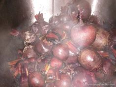 onions and carrots are cooking in a pot on the stove top, with steam coming from them