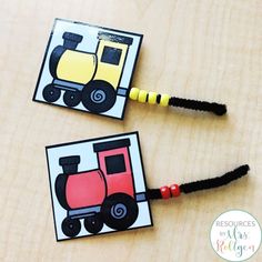 two matching cards with construction vehicles are on a wooden table and one has black braids