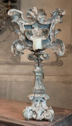 an ornate metal candle holder on top of a wooden table