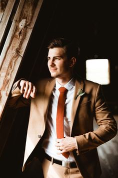 a man in a suit and orange tie