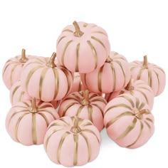 pink pumpkins with gold stripes are stacked on top of each other