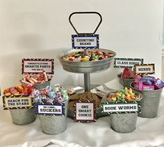 a table topped with buckets filled with lots of candy and candies next to each other