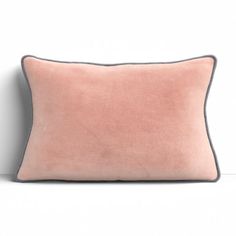 a pink pillow sitting on top of a white wall