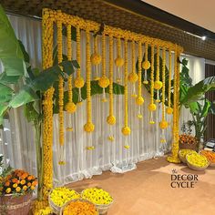 yellow flowers are hanging from the ceiling in front of white drapes