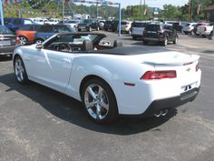 a white convertible car parked in a parking lot