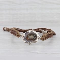 This lovely new bracelet is an authentic Nina Nguyen piece. This bracelet has a retail price of $195. Gem: Marbled Brown Geode Quartz Metal: Silver Toned Weight: 5.6 Grams  Stamps: Nina Nguyen Style: Brown woven chord with center charm Closure: Adjustable Drawstring Inner Circumference: 6"- 9 1/2" Width: 6.5 mm Charm: 16.7 x 26 mm Each piece is thoroughly examined and refinished as needed by our professional jewelers, graded by our in-house GIA (Gemological Institute of America) Graduate Gemolog Adjustable Sterling Silver Cuff Bracelet With Natural Stones, Adjustable Nature-inspired Jewelry For Jewelry Making, Bohemian Adjustable Jubilee Bracelet, Adjustable Artisan Sterling Silver Beaded Bracelets, Adjustable Sterling Silver Crystal Bracelet For Everyday, Adjustable Sterling Silver Crystal Bracelet, Everyday Adjustable Sterling Silver Crystal Bracelet, Adjustable Brown Sterling Silver Bracelets, Adjustable Silver Cuff Bracelet With Natural Stones