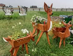 three wooden deer planters with flowers in them