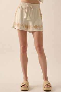 Linen-blend shorts. Floral embroidery. Elastic waist with tassel drawstring. Side pockets. Wide leg. Thigh length. Relaxed fit. 70% Rayon, 30% Linen. Imported. Designed in LA. Model wears size S. Cream Floral Embroidery Bottoms For Summer, Summer Floral Embroidery Cream Bottoms, Summer Cream Bottoms With Floral Embroidery, Bohemian Short Length Bottoms With Drawstring, Casual Embroidered Relaxed Fit Shorts, Casual Embroidered Shorts With Relaxed Fit, Casual Tassel Shorts For Spring, Casual Spring Shorts With Tassels, Casual Floral Embroidered Bottoms For Vacation