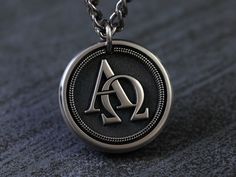 Fusing elegance and profound symbolism, our handcrafted Titanium Alpha Omega necklace is crafted with meticulous attention to detail and features a custom message of your choice on the backside of pendant. The Alpha Omega holds deep significance, representing faith in God's eternal presence and the belief in Christ as the source of salvation and fulfillment. Our 3D rendition of the Alpha Omega serves as a tangible symbol of unwavering faith and devotion. Perfect accessory for those who appreciate fine craftsmanship and symbolism. Elevate your style while affirming your faith with our handsome Titanium Alpha Omega Necklace. FRONT Engraving (raised engraving) This necklace features the Greek letters Alpha (Α) and Omega (Ω), symbolizing the eternal nature of God as the beginning and the end, Customizable Silver Necklaces, Luxury Silver Jewelry With Engraved Logo, Elegant Silver Jewelry With Engraved Logo, Luxury Engraved Logo Jewelry For Gift, Luxury Silver Necklace With Engraving Option, Elegant Jewelry With Engraved Logo For Gift, Silver Jewelry With Engraved Logo, Silver Round Jewelry With Engraved Logo, Silver Jewelry With Engraved Logo For Gift