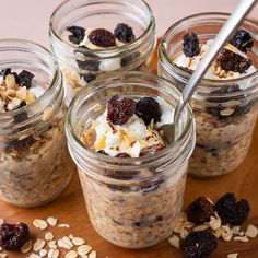 four jars filled with oatmeal and raisins on top of a wooden table