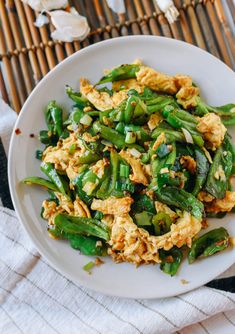 a white plate topped with green beans and eggs