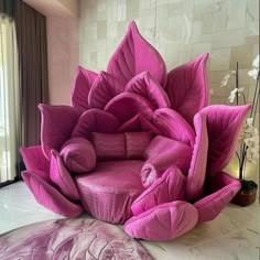 a pink flower shaped chair sitting on top of a white floor next to a window