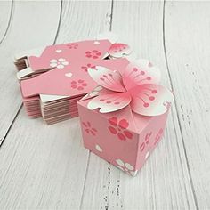 a pink gift box with paper flowers on it