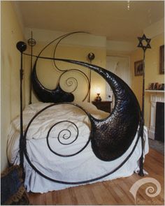 a black metal bed frame with spiral designs on the headboard and foot board, in a bedroom