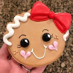 a close up of a person holding a decorated cookie