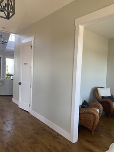 an empty living room with hard wood floors and white walls, is shown in the foreground