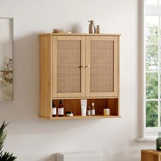 a wooden cabinet with some bottles on it and a plant in the corner next to it