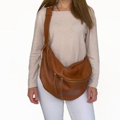 "A favourite and classic leather fanny pack for both women and men that tends to become a timeless design. This large sling bag stands out for the quality of its leather, for the capacity and for the stylish buckle used on the leather strap. It is a 3 style purse as you can wear it as a crossbody bag, as a shoulder bag and as a backpack. The large compartment is ideal to fit all your daily essentials like a water bottle, a make up case, wallet , phone, notebook and more. Ideal for travelling, for vacations and for everyday walks , you will use this bag for many years as it will never go out of style. Crafted from the finest Italian grain leather and matched with quality metal hardware and zippers. The inside of the bag is fully lined with water - repellent fabric in coral color and it has Everyday Smooth Grain Crossbody Belt Bag, Everyday Soft Leather Pouch Chest Bag, Sling Purse, Fanny Pack Women, Leather Sling Bag, Purse Gift, Leather Fanny Pack, Bag Stand, Bum Bag