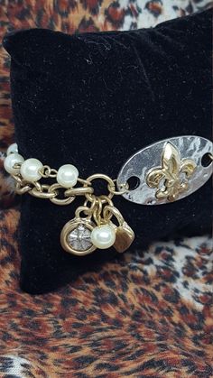 "Awesome Vintage hammered silver finish ID bracelet, that has a gold Fleur de Lis pendant, with antique gold finish chain links, toggle, and faux pearls. Charms that dangle include heart, big faux pearl, and dull silver cross or Celtic design, encased in a gold finish. Definitely a unique, fun piece! Measures 8\" inches and you can adjust it smaller. Center ID piece is 1\" inch wide x 1.5\" inches long. This has never been worn. Honestly, I had so much jewelry I wore then, this (along with some Celtic Design, Punk Rocker, Chain Links, Celtic Designs, Cute Bracelets, Hammered Silver, Glass Bead Necklace, Silver Cross, Chain Link Bracelet