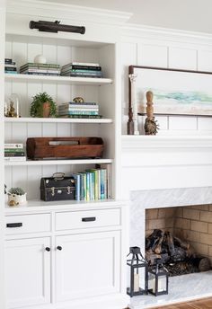 a living room with white bookcases and fireplace