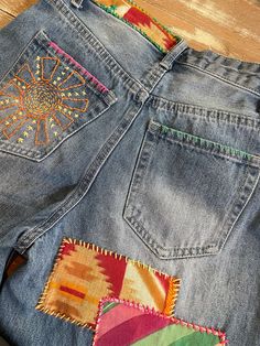 a pair of jeans with colorful patches on them