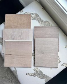 four different types of wood sitting on top of a white cushion next to a window