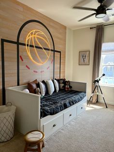 a bedroom with a bed, dressers and a basketball themed headboard on the wall