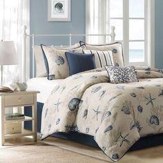 a bed with blue and white comforters in a bedroom