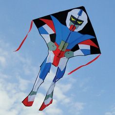 a colorful kite flying in the sky on a sunny day with blue skies and white clouds