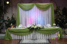 the table is set up with green and white linens for an elegant dinner party